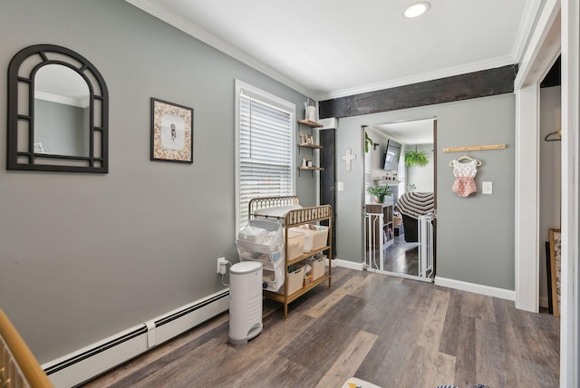 corridor with wood finished floors, ornamental molding, a baseboard heating unit, and baseboards