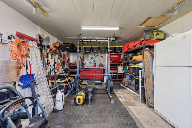 garage with a workshop area and freestanding refrigerator