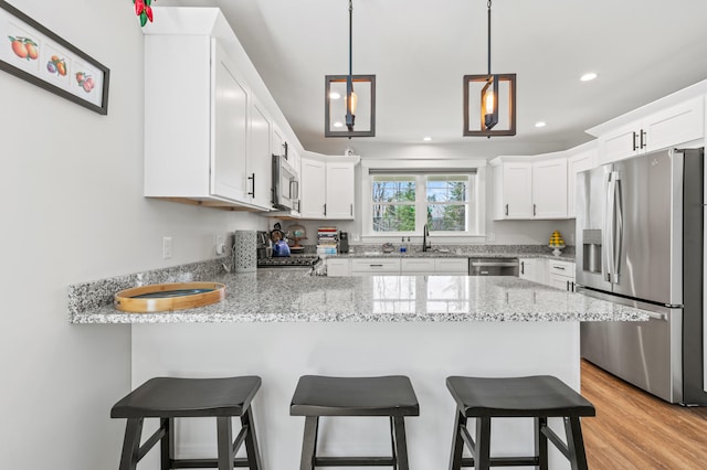 31 Neptune Dr, Brunswick, ME 04011 - kitchen with recessed lighting, white cabinetry, a peninsula, and stainless steel appliances