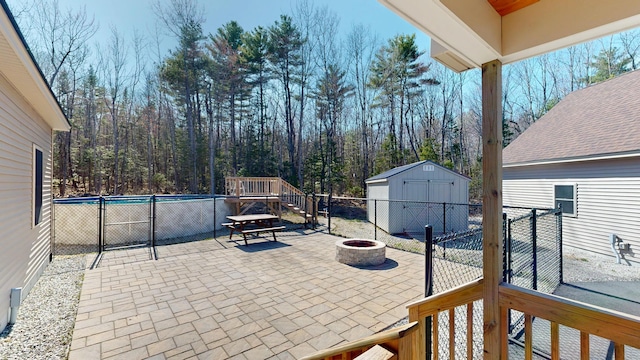 295 Cobb Hill Rd, Otisfield, ME 04270 - view of patio with an outbuilding, a fenced in pool, fence, a storage unit, and a fire pit