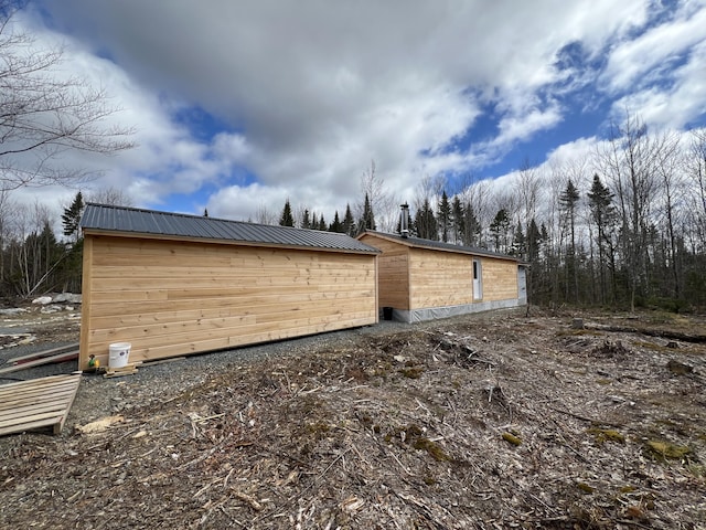 view of side of home featuring an outbuilding and metal roof