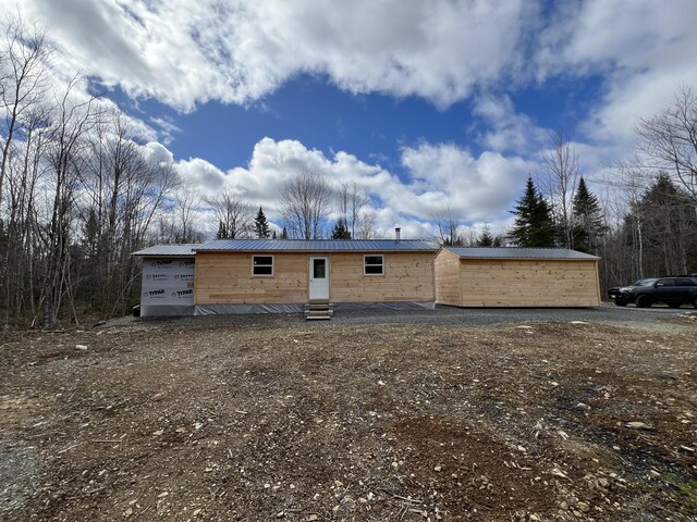 rear view of property with entry steps and metal roof