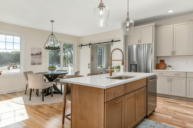 37 Cascade Cir Unit 26, Kennebunk, ME 04043 - kitchen with a barn door, light countertops, a sink, a wealth of natural light, and appliances with stainless steel finishes