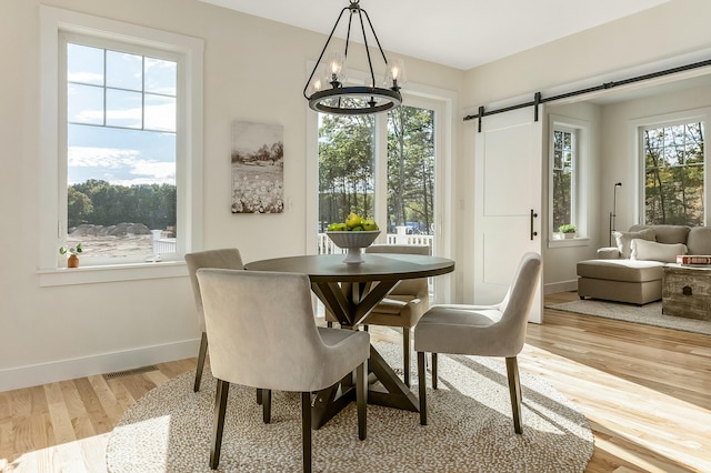 37 Cascade Cir Unit 26, Kennebunk, ME 04043 - dining area with a barn door, wood finished floors, baseboards, a notable chandelier, and visible vents