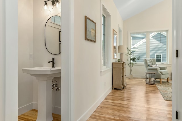 37 Cascade Cir Unit 26, Kennebunk, ME 04043 - bathroom featuring wood finished floors, lofted ceiling, baseboards, and a sink