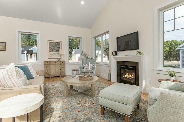 37 Cascade Cir Unit 26, Kennebunk, ME 04043 - living room featuring high vaulted ceiling, baseboards, a glass covered fireplace, and light wood-type flooring