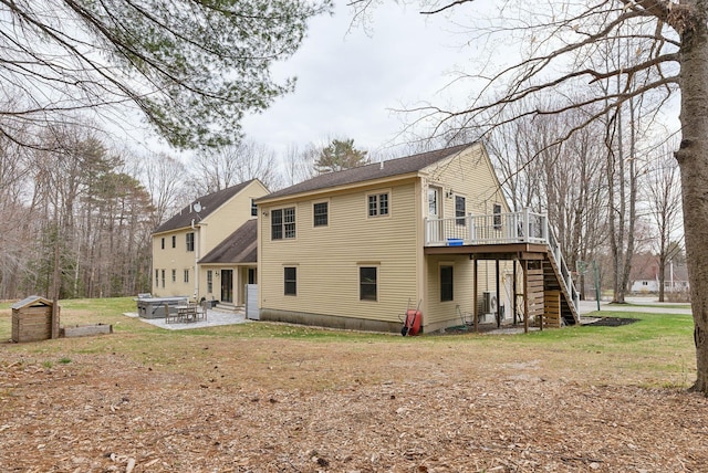 rear view of house featuring stairway, a patio, and a deck