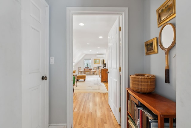 hallway featuring recessed lighting, light wood-style flooring, baseboards, and vaulted ceiling