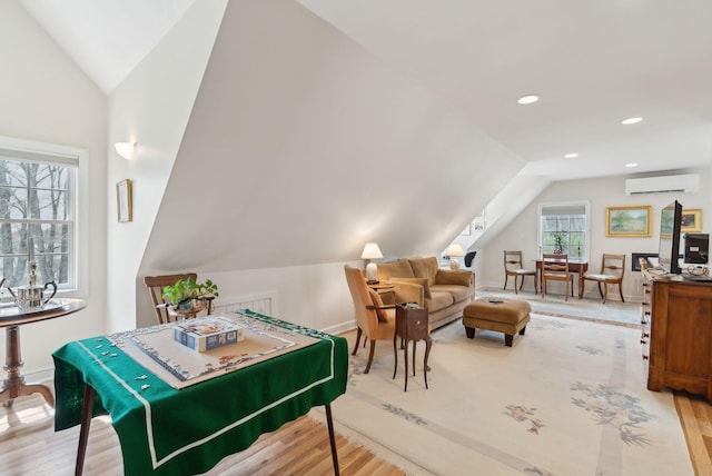 recreation room with baseboards, vaulted ceiling, a wall unit AC, and wood finished floors
