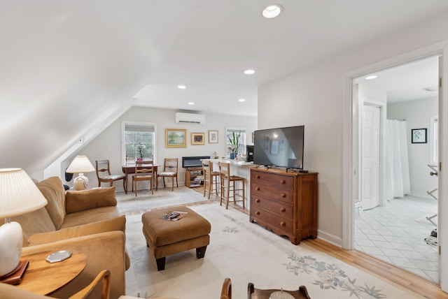 living area with light wood-style flooring, recessed lighting, baseboards, a wall unit AC, and vaulted ceiling