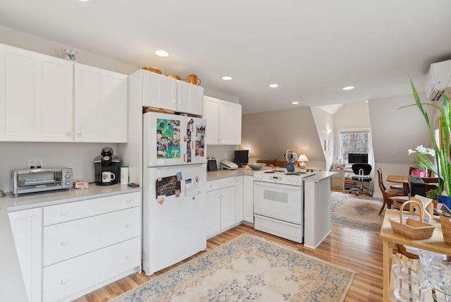 kitchen featuring a peninsula, a toaster, white appliances, open floor plan, and light wood-type flooring