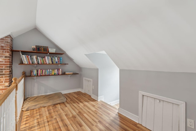 bonus room with baseboards, wood finished floors, and lofted ceiling
