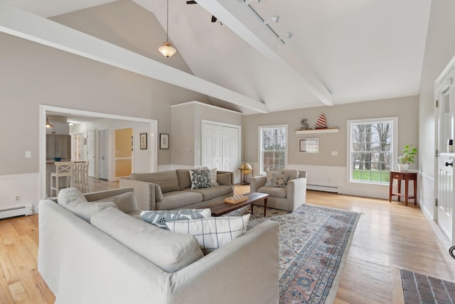 living room with rail lighting, a baseboard heating unit, wood finished floors, and high vaulted ceiling