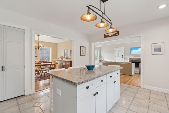 kitchen featuring a center island, open floor plan, plenty of natural light, and light tile patterned floors