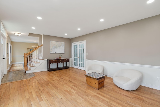 living area with an inviting chandelier, wood-type flooring, recessed lighting, baseboards, and stairway