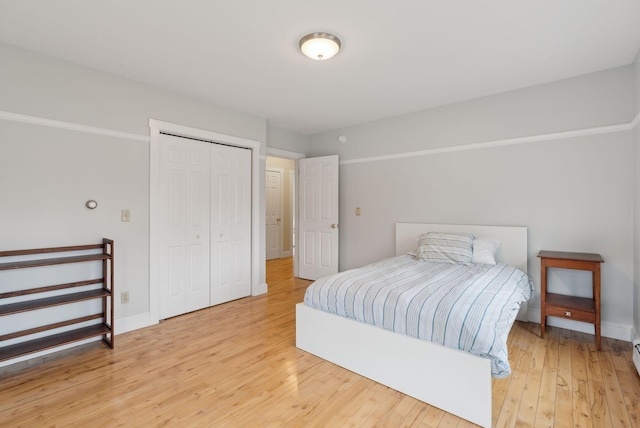 bedroom featuring baseboards, a closet, and light wood finished floors