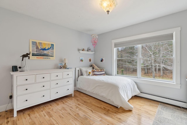 bedroom featuring light wood-style floors and a baseboard radiator