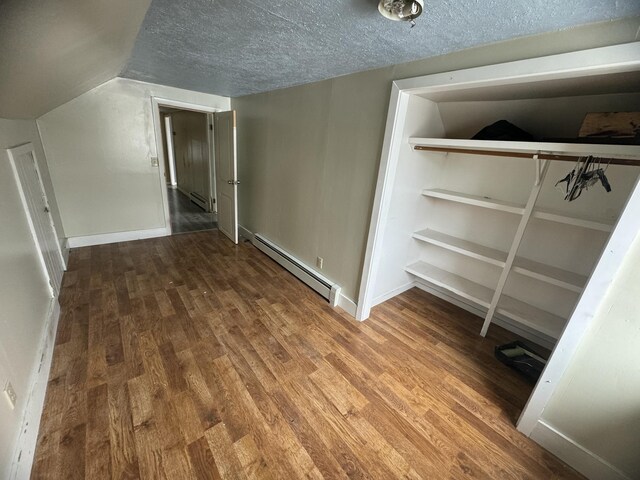 334 Main St, Madawaska, ME 04756 - bonus room featuring a baseboard heating unit, wood finished floors, a textured ceiling, and baseboards