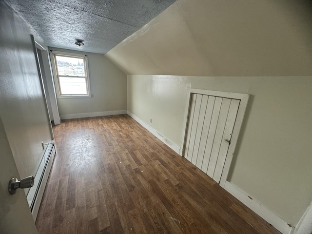 334 Main St, Madawaska, ME 04756 - bonus room with wood finished floors, baseboard heating, vaulted ceiling, baseboards, and a textured ceiling