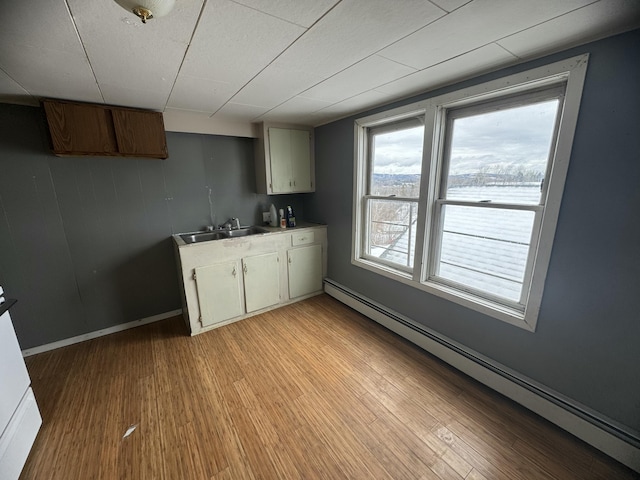 334 Main St, Madawaska, ME 04756 - kitchen with a baseboard heating unit, light wood-style flooring, light countertops, and a sink