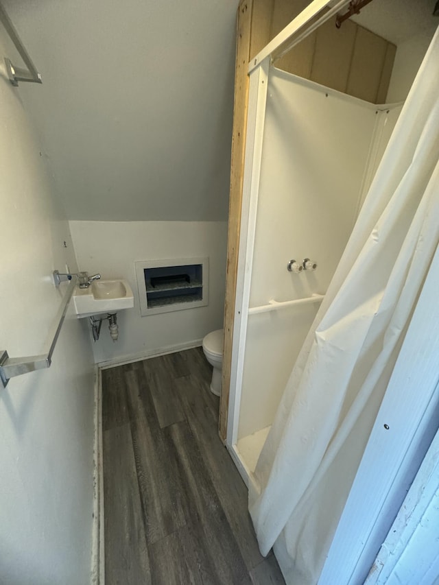 334 Main St, Madawaska, ME 04756 - bathroom with toilet, a sink, wood finished floors, a shower with shower curtain, and vaulted ceiling