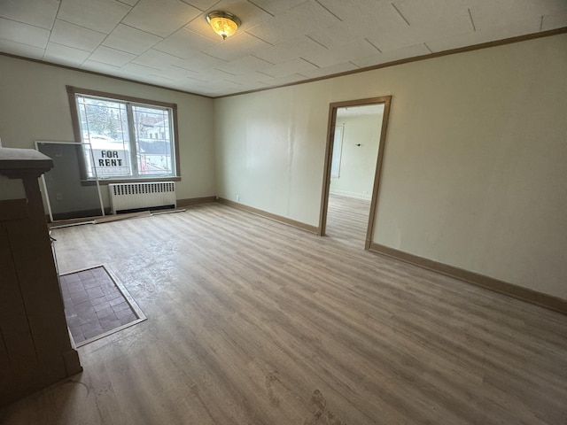 334 Main St, Madawaska, ME 04756 - empty room featuring radiator, light wood-style floors, and baseboards