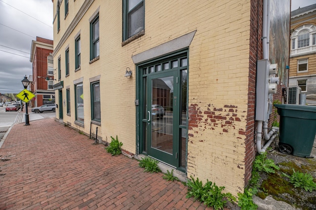 doorway to property featuring brick siding