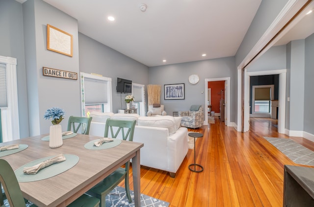 living area with baseboards, recessed lighting, and light wood-style flooring