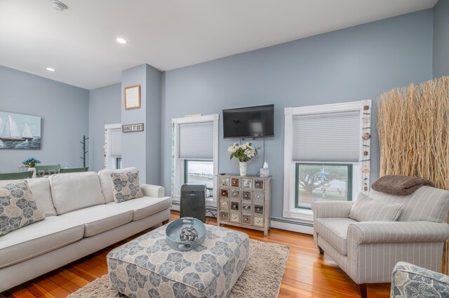 living area with baseboard heating, recessed lighting, and wood finished floors