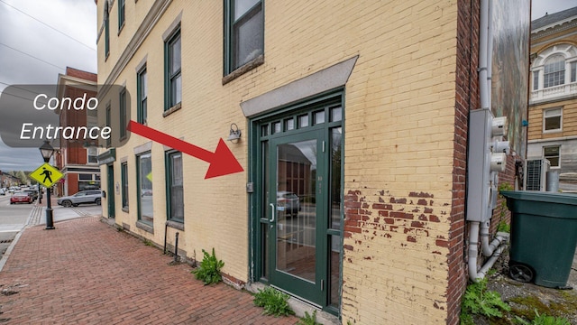 entrance to property featuring brick siding