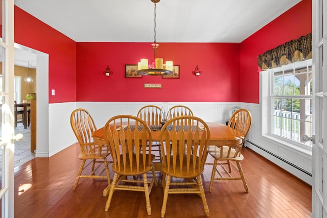 263 Ellsworth Rd, Aurora, ME 04408 - dining room featuring wood-type flooring, a notable chandelier, baseboard heating, and wainscoting
