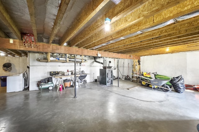 unfinished below grade area featuring heating unit and washer / dryer
