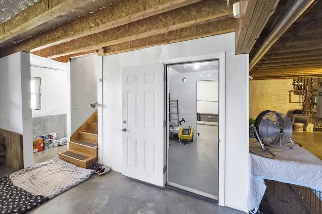miscellaneous room with stairway and finished concrete flooring