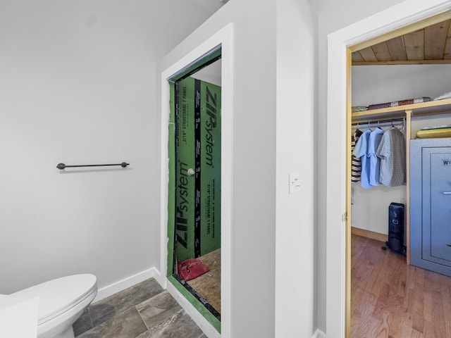 full bathroom with toilet and baseboards