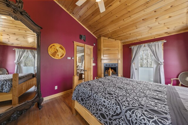 bedroom with hardwood / wood-style floors, baseboards, wooden ceiling, vaulted ceiling, and a ceiling fan