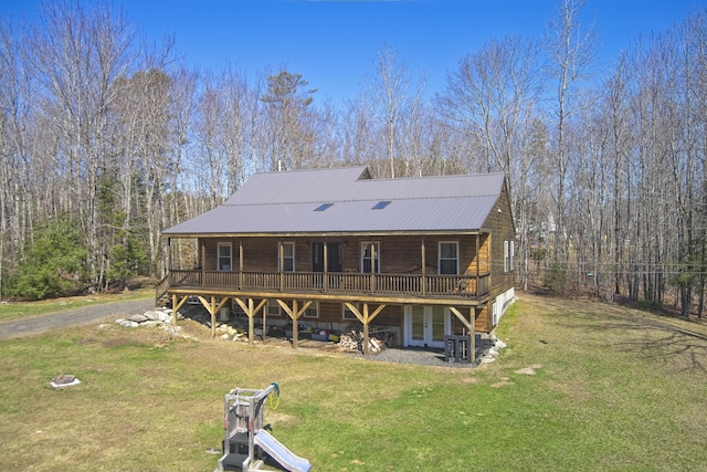 back of property with a lawn, a deck, metal roof, and french doors
