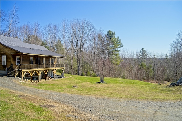view of yard with stairway, a view of trees, and a wooden deck