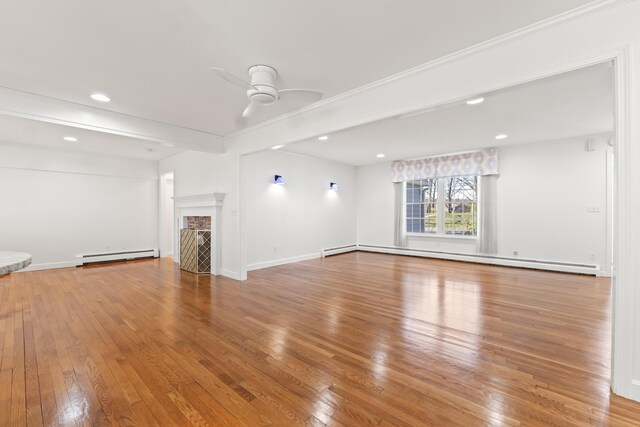 unfurnished living room with a baseboard heating unit, a ceiling fan, hardwood / wood-style flooring, a fireplace, and a baseboard radiator