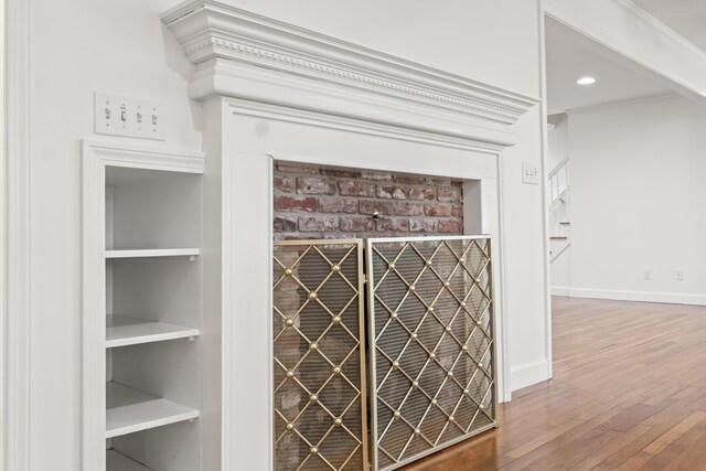 room details featuring baseboards, wood finished floors, recessed lighting, and built in features