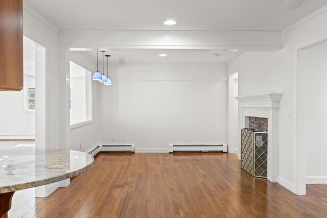 unfurnished living room featuring a baseboard heating unit, recessed lighting, baseboard heating, crown molding, and wood-type flooring