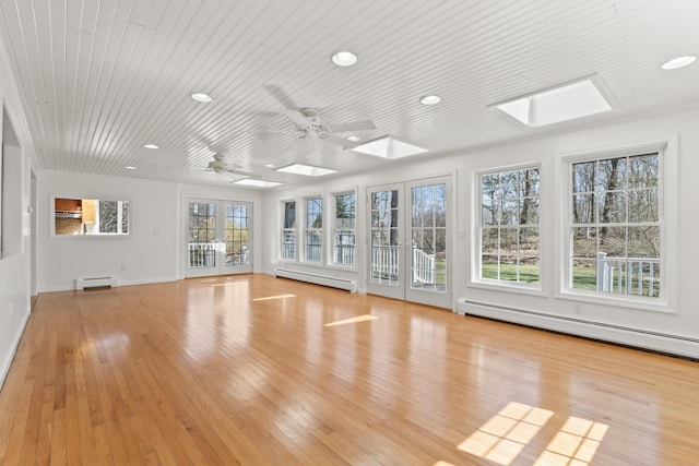 unfurnished sunroom featuring baseboard heating, a baseboard heating unit, french doors, and a skylight
