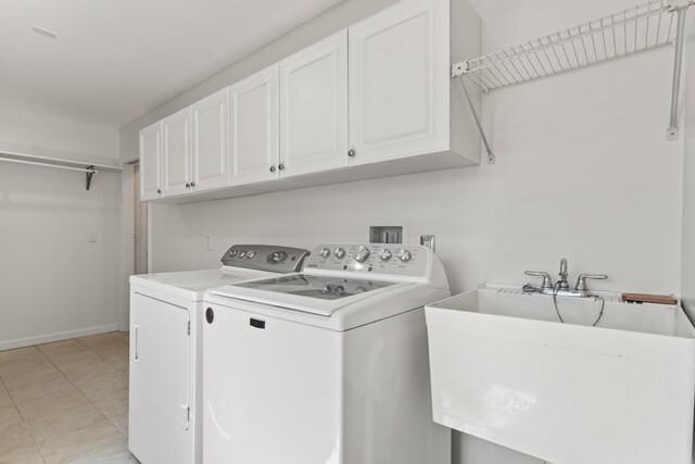 clothes washing area with washing machine and clothes dryer, baseboards, a sink, and cabinet space