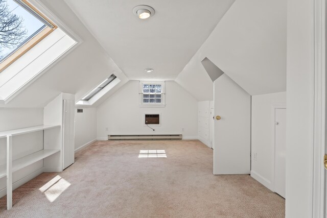 bonus room with a baseboard radiator, light colored carpet, and vaulted ceiling with skylight