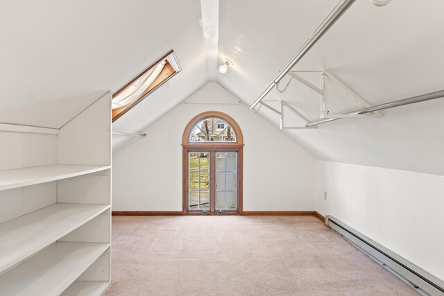 additional living space with baseboard heating, baseboards, carpet, and vaulted ceiling with skylight
