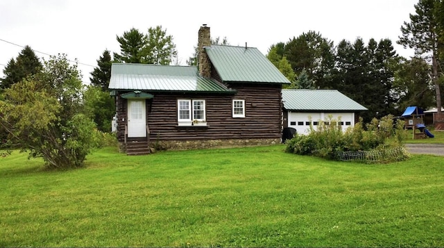 101 Mechanic St, Presque Isle, ME 04769 - view of side of property with a chimney, log exterior, a garage, a yard, and metal roof