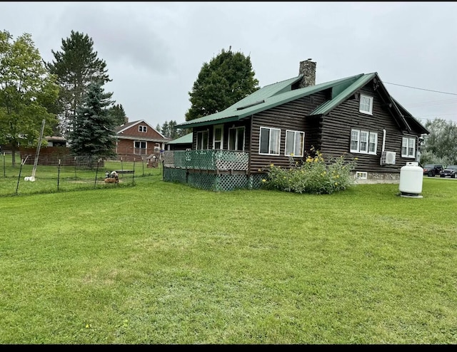 101 Mechanic St, Presque Isle, ME 04769 - back of house featuring a chimney, metal roof, fence, log siding, and a lawn