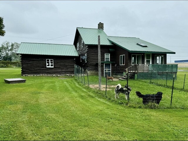 101 Mechanic St, Presque Isle, ME 04769 - rear view of property with a chimney, log siding, fence, a yard, and metal roof
