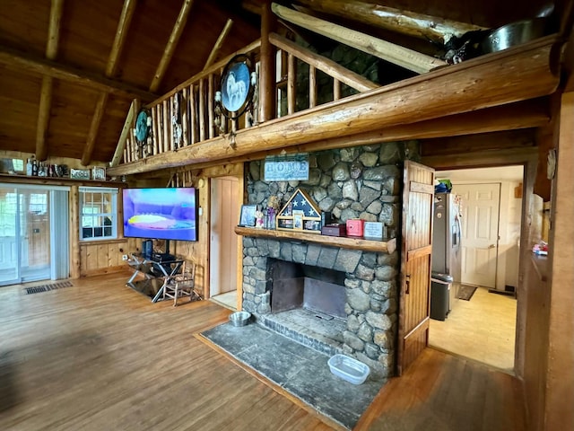 101 Mechanic St, Presque Isle, ME 04769 - living room with beamed ceiling, a stone fireplace, wood finished floors, and high vaulted ceiling