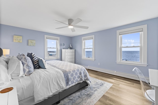 175 Beach Ave Unit 2, Kennebunk, ME 04043 - bedroom with a baseboard heating unit, wood finished floors, ceiling fan, and multiple windows
