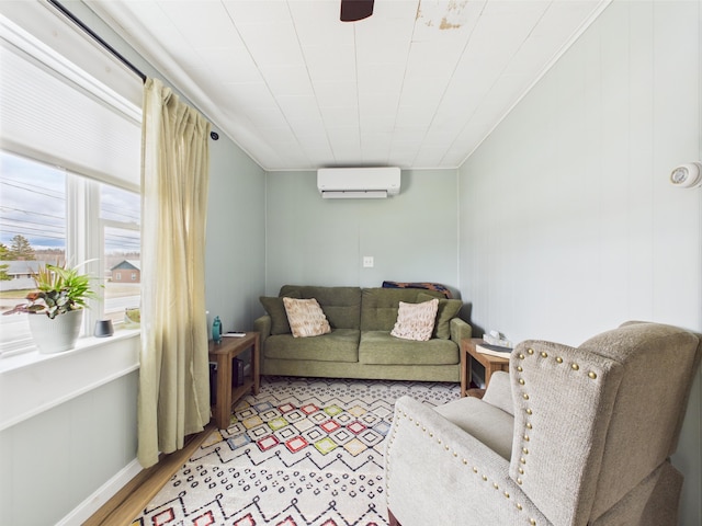 living area featuring light wood-style flooring, ceiling fan, and a wall mounted AC